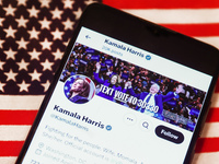 Kamala Harris social media site on X, formerly known as Twitter, is displayed on a mobile phone screen with US flag in the background for il...