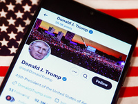 Donald J. Trump social media site on X, formerly known as Twitter, is displayed on a mobile phone screen with US flag in the background for...