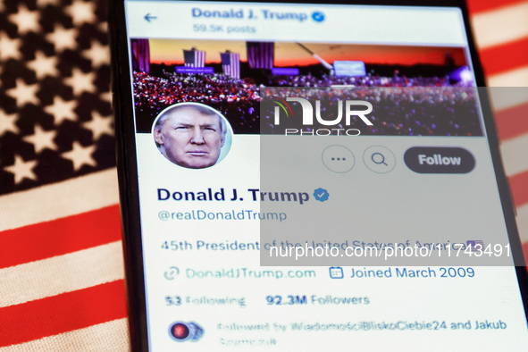 Donald J. Trump social media site on X, formerly known as Twitter, is displayed on a mobile phone screen with US flag in the background for...