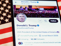 Donald J. Trump social media site on X, formerly known as Twitter, is displayed on a mobile phone screen with US flag in the background for...