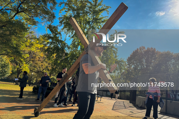 A man carries a large wooden cross near the White House in Washington DC, USA on 05 November, 2024. 