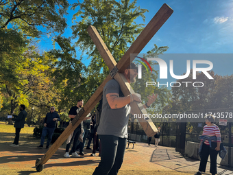 A man carries a large wooden cross near the White House in Washington DC, USA on 05 November, 2024. (