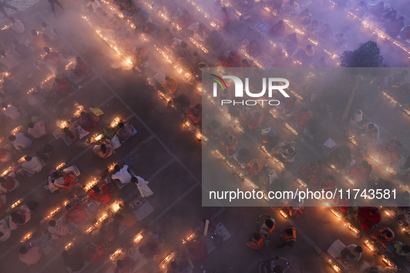 Hindu devotees sit together on the floor of Loknath Temple to observe the Rakher Upobash festival to honor Baba Lokenath, an 18th Century Hi...