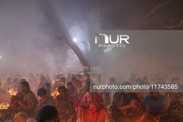 Hindu devotees sit together on the floor of Loknath Temple to observe the Rakher Upobash festival to honor Baba Lokenath, an 18th Century Hi...