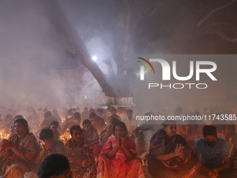 Hindu devotees sit together on the floor of Loknath Temple to observe the Rakher Upobash festival to honor Baba Lokenath, an 18th Century Hi...