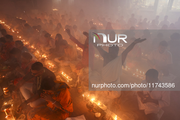 Hindu devotees sit together on the floor of Loknath Temple to observe the Rakher Upobash festival to honor Baba Lokenath, an 18th Century Hi...