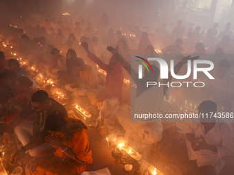 Hindu devotees sit together on the floor of Loknath Temple to observe the Rakher Upobash festival to honor Baba Lokenath, an 18th Century Hi...