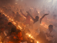 Hindu devotees sit together on the floor of Loknath Temple to observe the Rakher Upobash festival to honor Baba Lokenath, an 18th Century Hi...