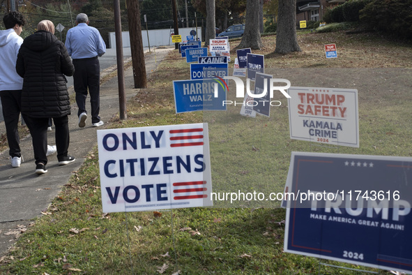 Presidential candidates Donald Trump and Kamala Harris' signs are seen outside a Vote Center in Fairfax County, Virginia, on November 5, 202...