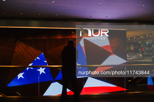 A man stands in front of a display screen showing the American flag on Election Day 2024 in Minneapolis, Minnesota, on November 5, 2024. 