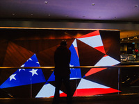 A man stands in front of a display screen showing the American flag on Election Day 2024 in Minneapolis, Minnesota, on November 5, 2024. (