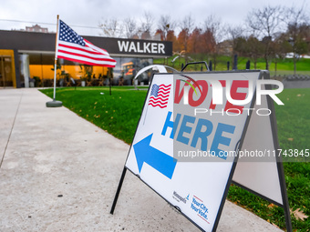 A sign points to a polling location and an American flag stands in front of the Walker Art Center in Minneapolis, Minnesota, on November 5,...