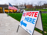 A sign points to a polling location and an American flag stands in front of the Walker Art Center in Minneapolis, Minnesota, on November 5,...