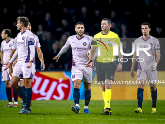 Girona FC defender David Lopez and referee Michael Oliver participate in the match between PSV and Girona at the Philips Stadium for the UEF...