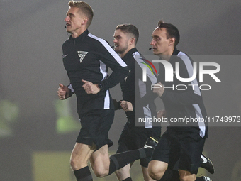 Referee Scott Oldham leads his assistants as they warm up during the Sky Bet League 1 match between Burton Albion and Crawley Town at the Pi...