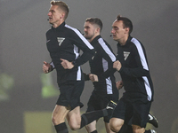 Referee Scott Oldham leads his assistants as they warm up during the Sky Bet League 1 match between Burton Albion and Crawley Town at the Pi...