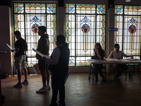 Voters wait to cast their ballots for President, Congress,and local races for the 2024 election in a room of stained glass windows at the Mu...