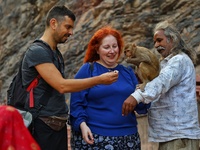 A tourist poses with a macaque at the Shrine Galta Ji Temple in Jaipur, Rajasthan, India, on November 5, 2024. (