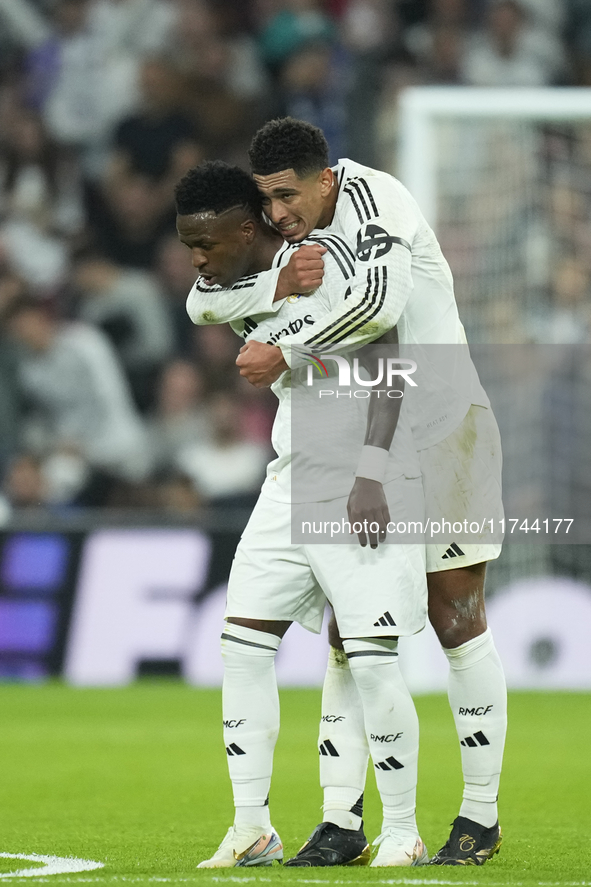 Vinicius Junior left winger of Real Madrid and Brazil celebrates after scoring his sides first goal with Jude Bellingham central midfield of...