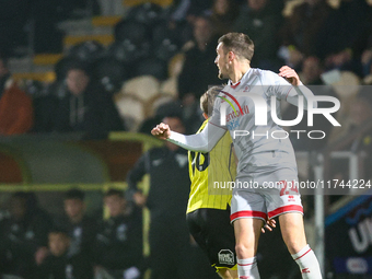 #24, Toby Mullarkey of Crawley Town outjumps #16, Jack Cooper-Love of Burton Albion during the Sky Bet League 1 match between Burton Albion...