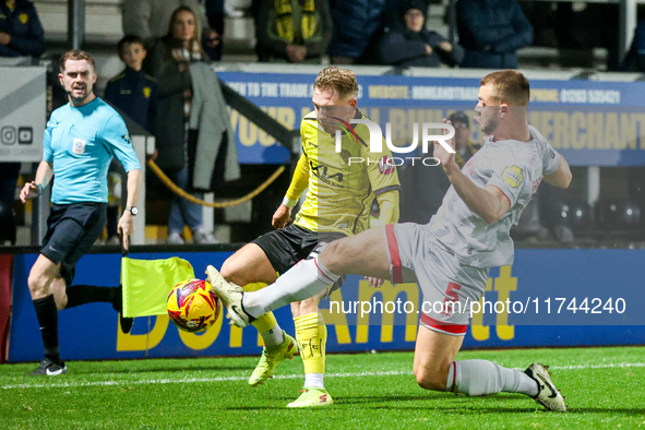 Number 34, Ben Whitfield of Burton Albion, is intercepted by number 5, Charlie Barker of Crawley Town during the Sky Bet League 1 match betw...