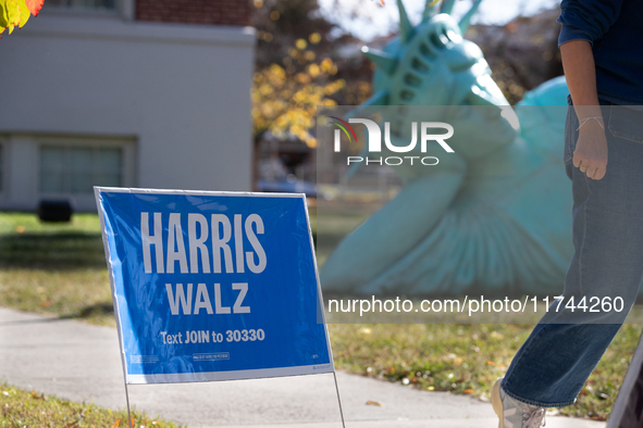 A Harris Walz campaign sign stands in front of Zaq Landsberg's ''Reclining Liberty'' statue at the Museum of Contemporary Art, a polling pla...