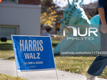 A Harris Walz campaign sign stands in front of Zaq Landsberg's ''Reclining Liberty'' statue at the Museum of Contemporary Art, a polling pla...