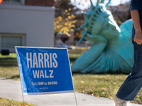 A Harris Walz campaign sign stands in front of Zaq Landsberg's ''Reclining Liberty'' statue at the Museum of Contemporary Art, a polling pla...