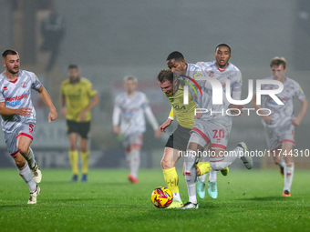 Number 34, Ben Whitfield of Burton Albion, and number 20, Joy Mukena of Crawley Town, battle for possession during the Sky Bet League 1 matc...