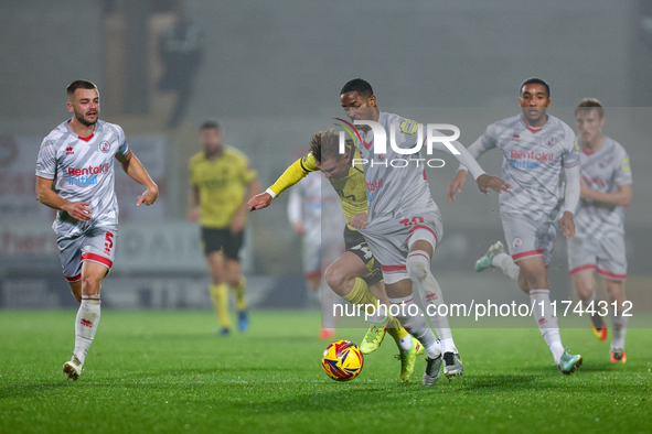 Number 34, Ben Whitfield of Burton Albion, and number 20, Joy Mukena of Crawley Town, battle for possession during the Sky Bet League 1 matc...