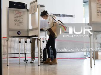 Voters stand in line at a local polling station in Washington, DC, on November 5, 2024. Americans cast their ballots in the presidential rac...