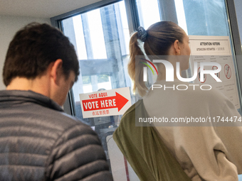 Voters stand in line at a local polling station in Washington, DC, on November 5, 2024. Americans cast their ballots in the presidential rac...