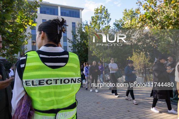 Voters stand in line at a local polling station in Washington, DC, on November 5, 2024. Americans cast their ballots in the presidential rac...