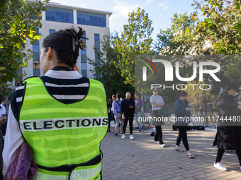 Voters stand in line at a local polling station in Washington, DC, on November 5, 2024. Americans cast their ballots in the presidential rac...