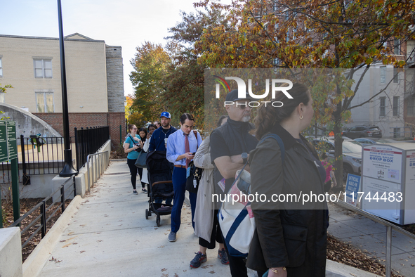 Voters stand in line at a local polling station in Washington, DC, on November 5, 2024. Americans cast their ballots in the presidential rac...