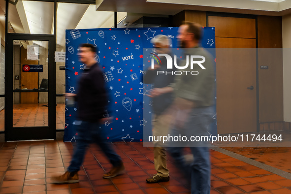 People walk past an election-themed display banner inside the Hennepin County Government Center in Minneapolis, Minnesota, on November 5, 20...