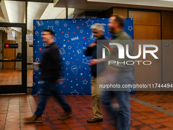 People walk past an election-themed display banner inside the Hennepin County Government Center in Minneapolis, Minnesota, on November 5, 20...