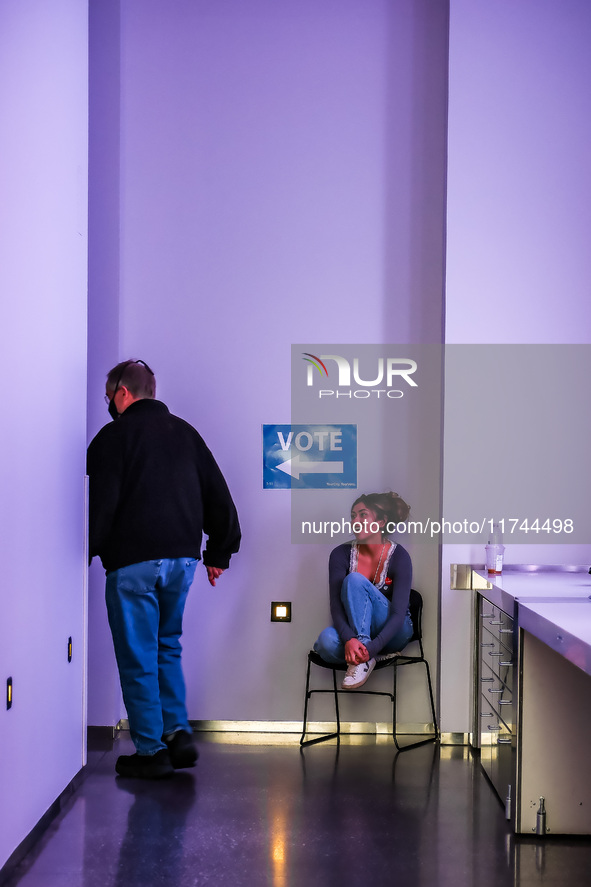 A voter walks past an election official to vote at a polling location inside the Guthrie Theatre in Minneapolis, Minnesota, on November 5, 2...