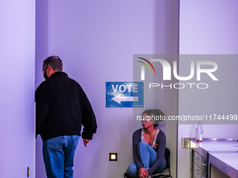 A voter walks past an election official to vote at a polling location inside the Guthrie Theatre in Minneapolis, Minnesota, on November 5, 2...