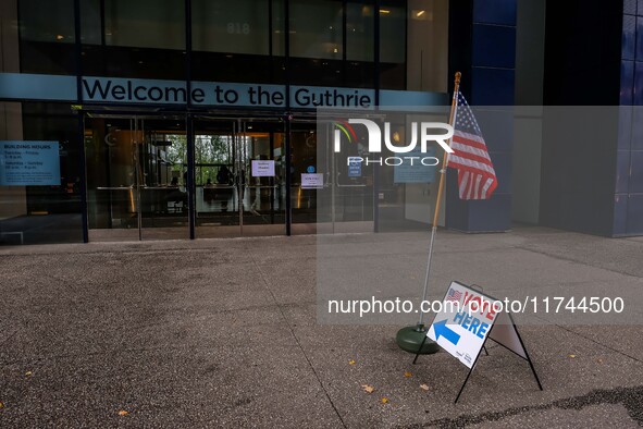 A sign and flag indicating a polling place for voters are seen next to the Guthrie Theatre on Election Day 2024 in Minneapolis, Minnesota, o...