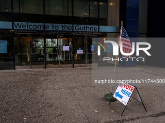 A sign and flag indicating a polling place for voters are seen next to the Guthrie Theatre on Election Day 2024 in Minneapolis, Minnesota, o...