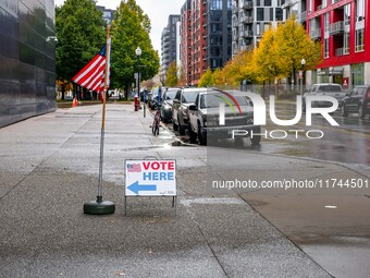 A sign and flag indicating a polling place for voters are seen next to the Guthrie Theatre on Election Day 2024 in Minneapolis, Minnesota, o...