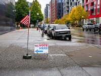 A sign and flag indicating a polling place for voters are seen next to the Guthrie Theatre on Election Day 2024 in Minneapolis, Minnesota, o...