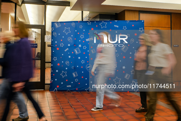 People walk past an election-themed display banner inside the Hennepin County Government Center in Minneapolis, Minnesota, on November 5, 20...