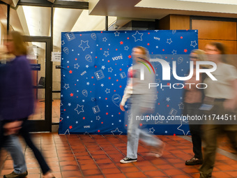 People walk past an election-themed display banner inside the Hennepin County Government Center in Minneapolis, Minnesota, on November 5, 20...