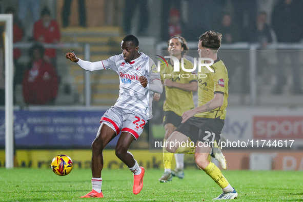 Number 22, Ade Adeyemo of Crawley Town, is in attacking action as number 21, Alex Bannon of Burton Albion, challenges during the Sky Bet Lea...