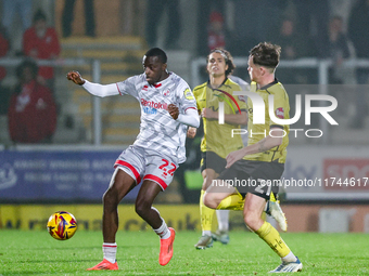 Number 22, Ade Adeyemo of Crawley Town, is in attacking action as number 21, Alex Bannon of Burton Albion, challenges during the Sky Bet Lea...