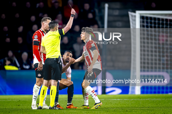 PSV Eindhoven defender Matteo Dams receives a yellow card during the match between PSV and Girona at the Philips Stadium for the UEFA Champi...