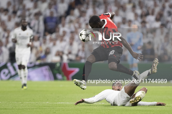 Jude Bellingham of Real Madrid and Yunus Musah of AC Milan fight for the ball during the UEFA Champions League 2024/25 match between Real Ma...