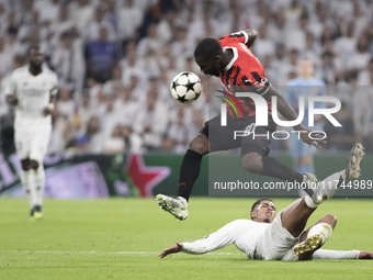 Jude Bellingham of Real Madrid and Yunus Musah of AC Milan fight for the ball during the UEFA Champions League 2024/25 match between Real Ma...